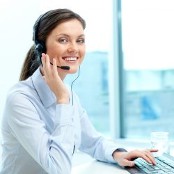 Portrait of young operator with headset looking at camera with friendly smile